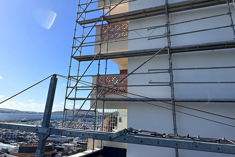 Trabajos de rehabilitación de fachada en edificio en Palma con andamios y vistas al mar