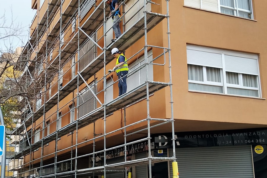 Trabajos de rehabilitación de fachada en Portals Nous con operarios en andamio